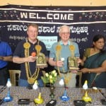 Rtns Don and Bob being felicitated by the HM as Rtn. Rajendra Rai applauds